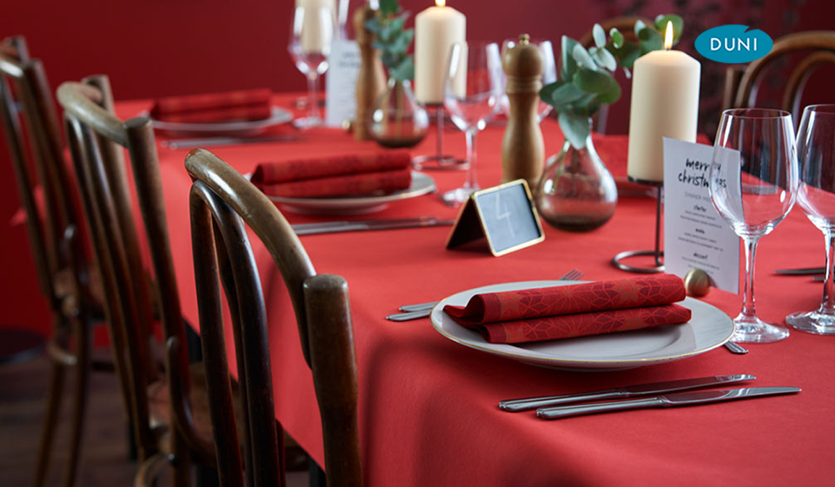 Ein weihnachtlich gedeckter Tisch mit einer roten Tischdecke und roten Servietten