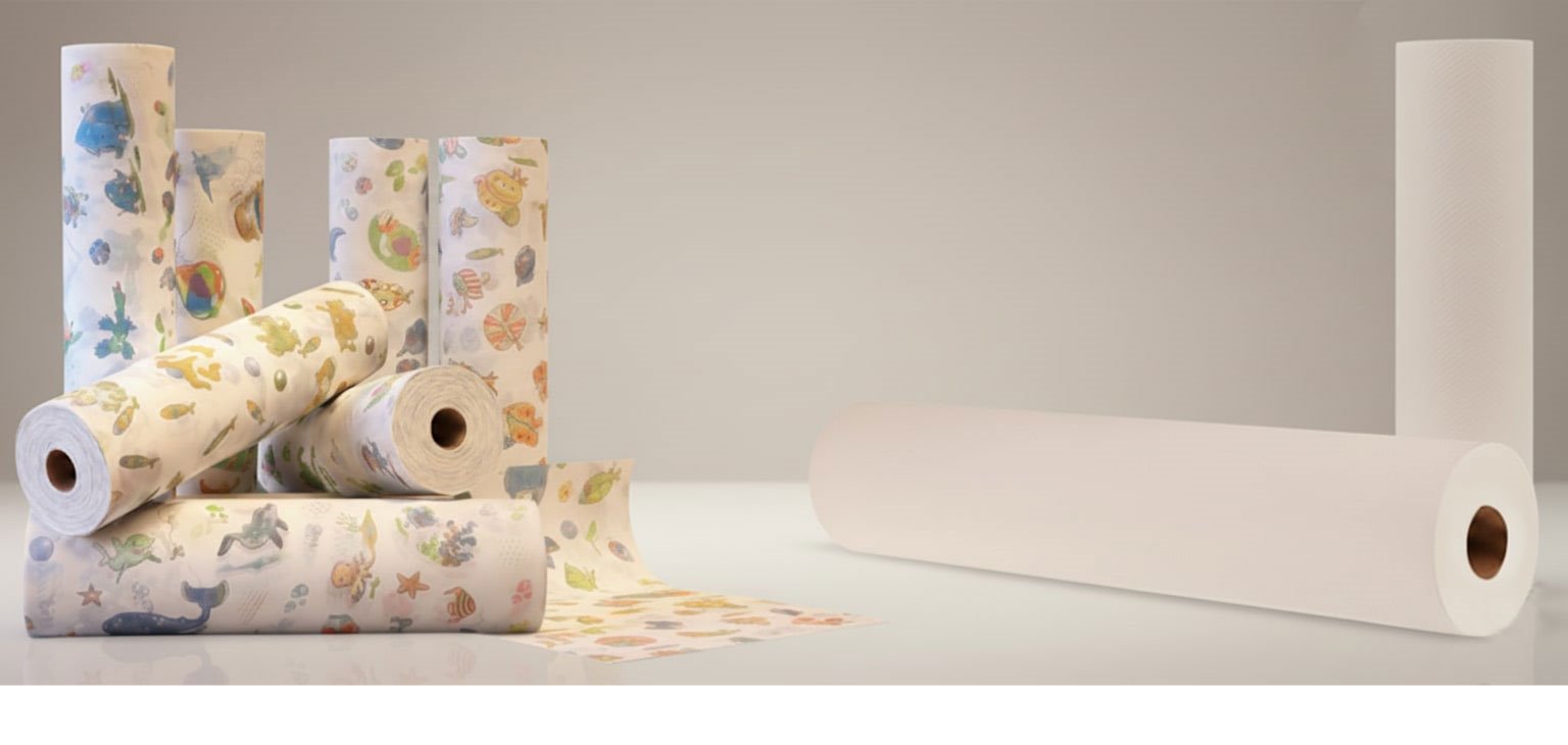 Rollen mit Papier-Liegenauflagen auf Behandlungsliege, hygienisches Arztkrepp im hellen Zahnarztpraxis-Ambiente