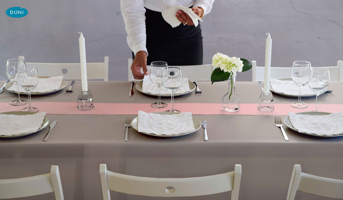 Elegantes Duni-Tischband über fein gedeckter Tafel, farblich abgestimmt mit Servietten und Geschirr im edlen Restaurantambiente