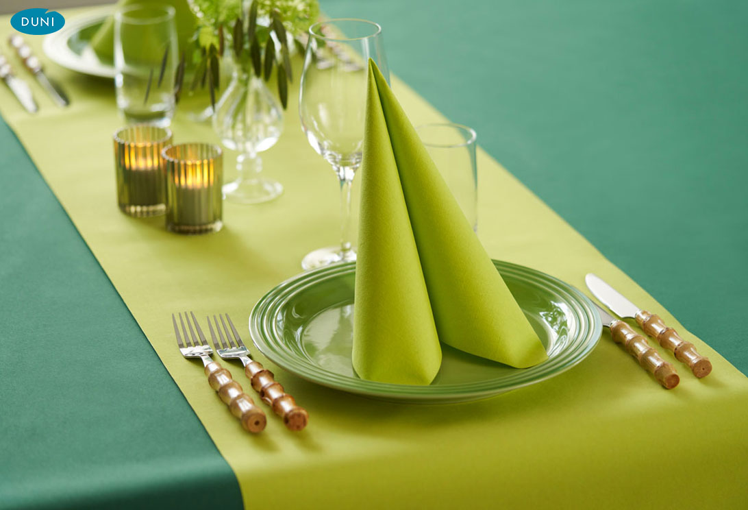 Leuchtend farbige Duni-Tischläufer auf elegant gedeckten Tischen, harmonisch kombiniert mit Servietten und Geschirr im Restaurantambiente