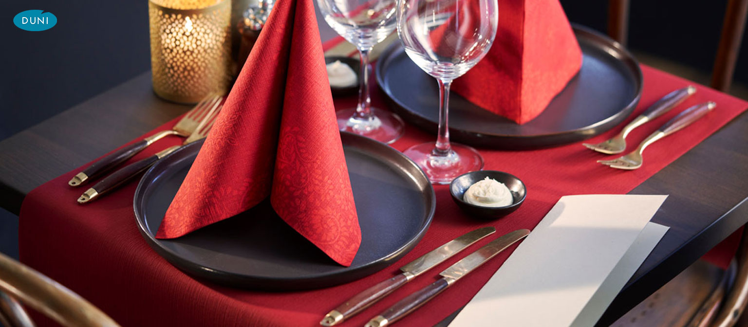 Leuchtend farbige Duni-Tischläufer auf elegant gedeckten Tischen, harmonisch kombiniert mit Servietten und Geschirr im Restaurantambiente