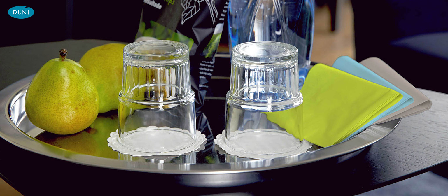 Quadratische Zelltuch-Untersetzer unter Gläsern und Tassen, saugfähig und dezent für saubere Tischflächen im Gastro-Ambiente