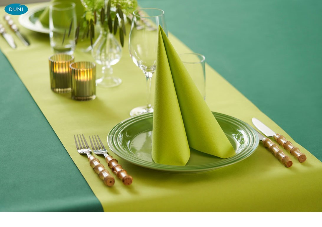 Leuchtend farbige Duni-Tischläufer auf elegant gedeckten Tischen, harmonisch kombiniert mit Servietten und Geschirr im Restaurantambiente