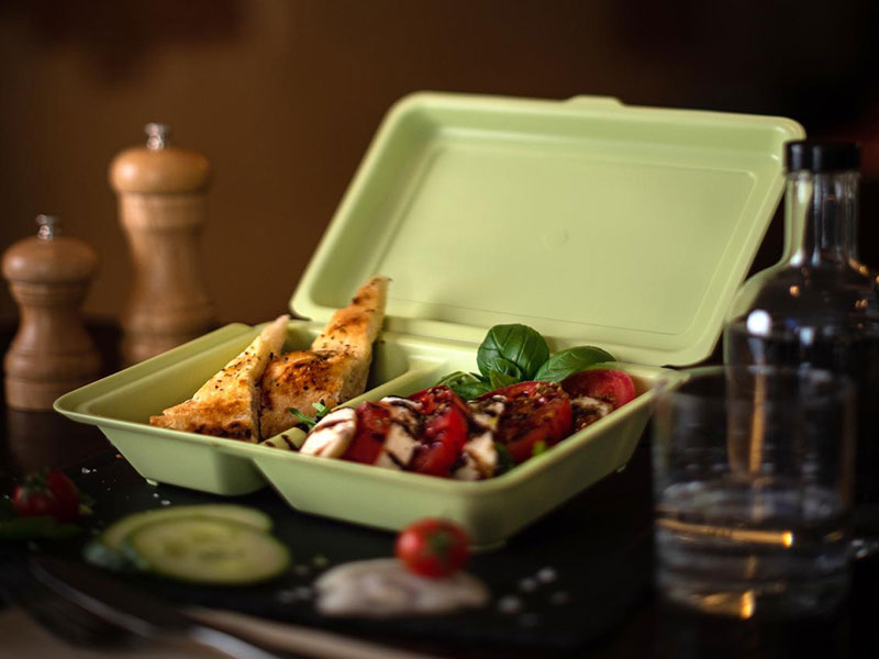 Eine Mehrweg Take Away Schale gefüllt mit Essen auf einem Tisch