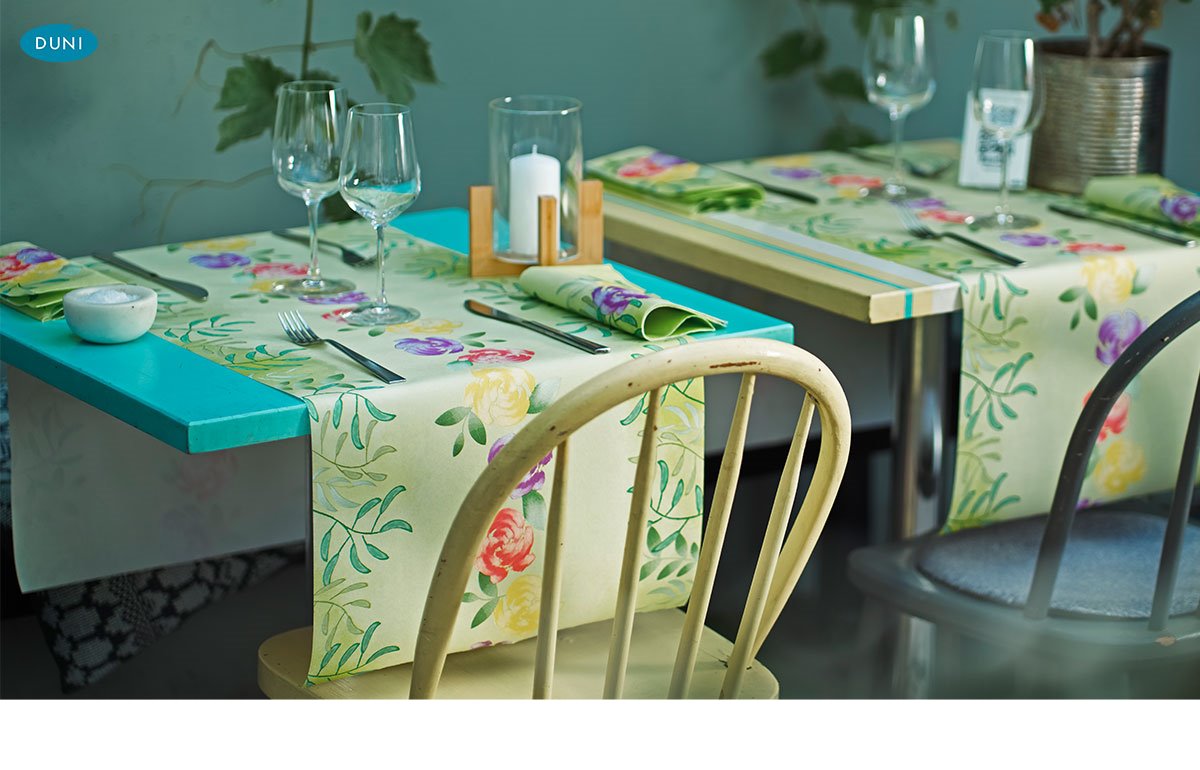 Tischläufer von Duni mit floralen, saisonalen Mustern, dekorativ auf gedeckter Tafel mit passenden Servietten und zarten Blütenakzenten